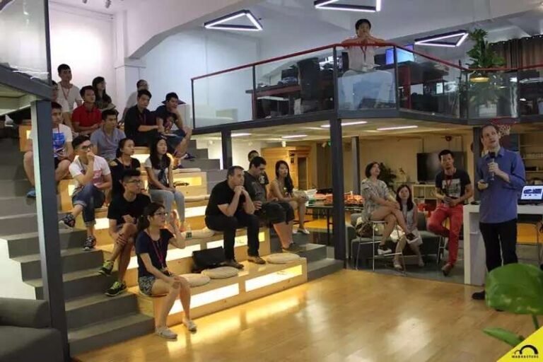 An audience seated on steps during a design gathering